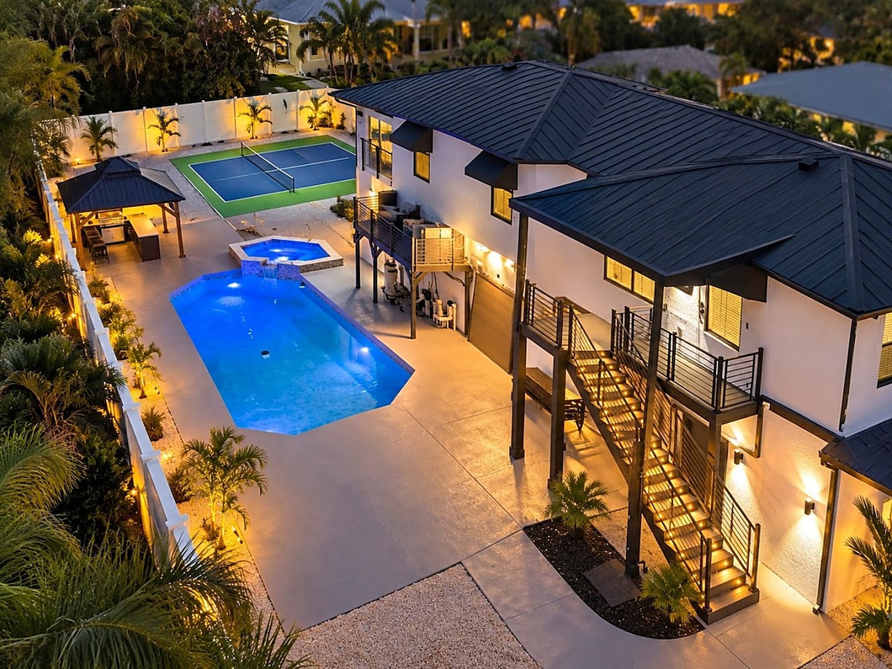 The Alexandra at dusk — heated pool, pickleball court and gazebo seen from above